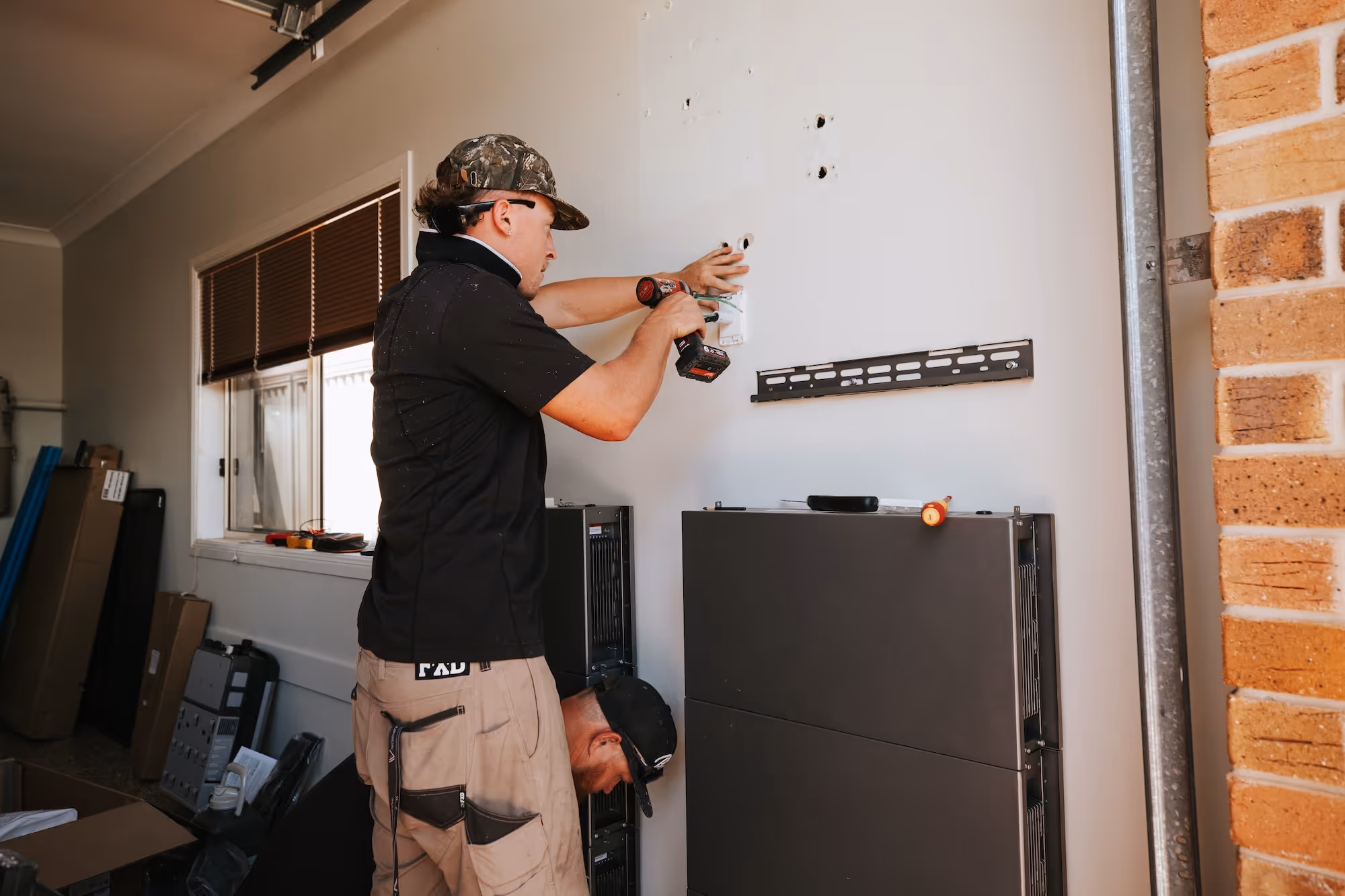 Home solar battery storage unit installed on an external wall, allowing for energy independence and backup power.