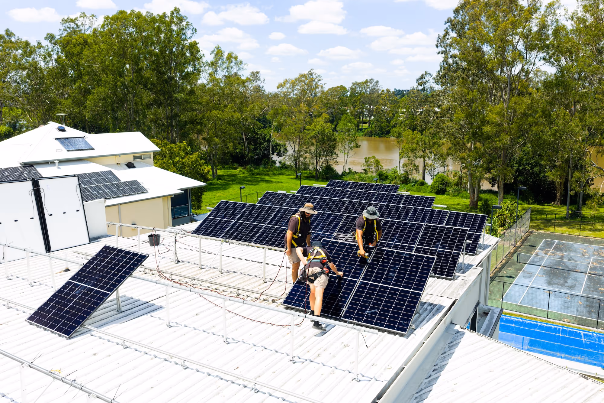 A qualified LMS electrician securing solar panels to a roof.